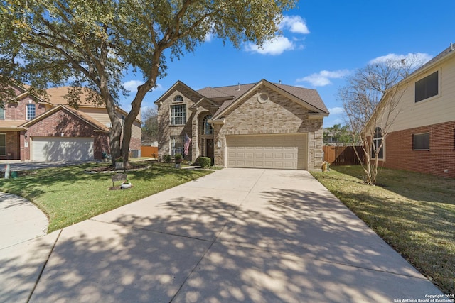 traditional-style home featuring a garage, concrete driveway, fence, a front lawn, and brick siding