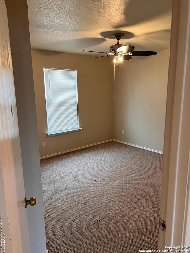 unfurnished room featuring ceiling fan, a textured ceiling, baseboards, and carpet flooring