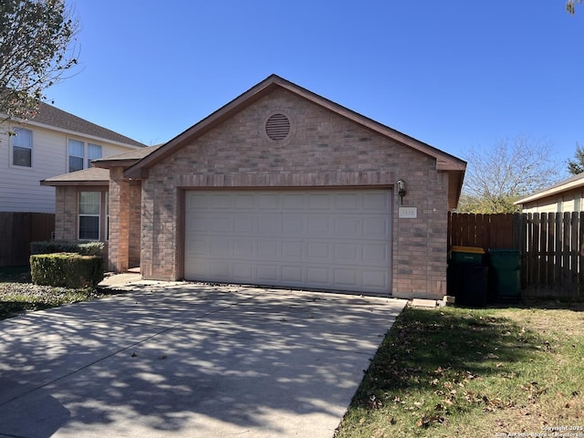 view of front of house with an attached garage, fence, concrete driveway, and brick siding