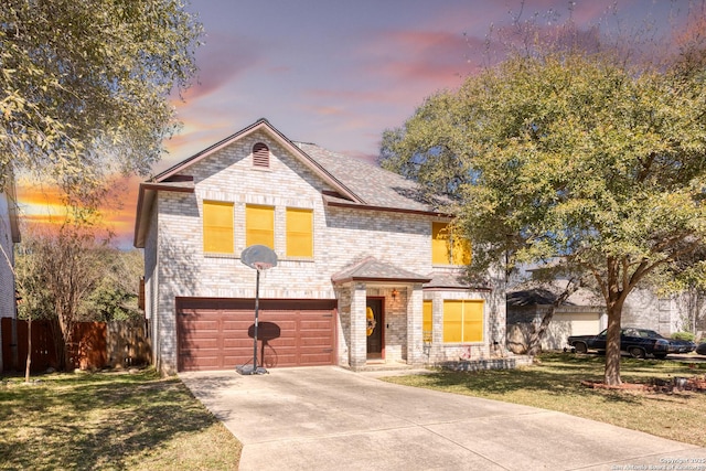 view of front of home with concrete driveway, an attached garage, fence, a front lawn, and brick siding