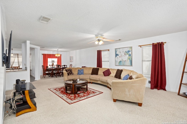 carpeted living room with visible vents, ceiling fan, and a textured ceiling