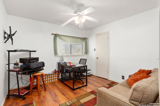 home office featuring ceiling fan, a textured ceiling, and wood finished floors