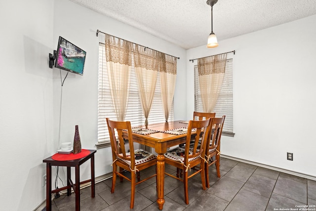 dining area featuring a textured ceiling and tile patterned floors