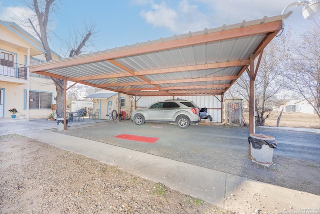 view of parking with driveway and a carport