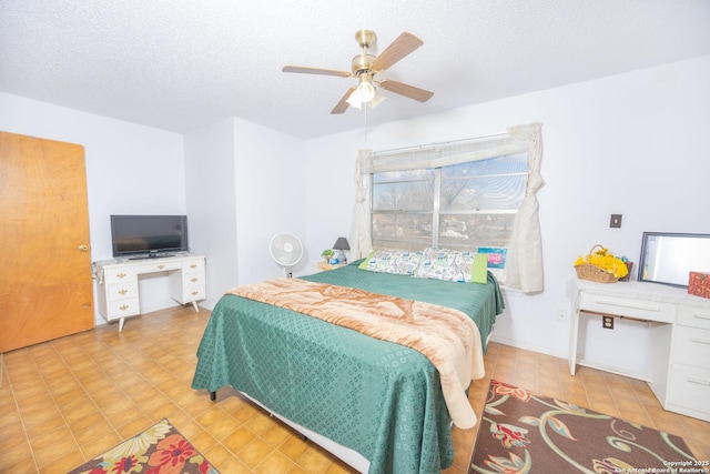 bedroom with a ceiling fan and a textured ceiling