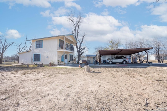 exterior space featuring a carport, driveway, and a balcony