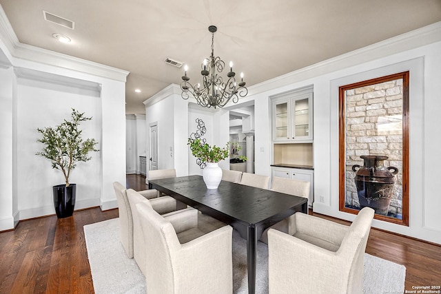 dining area featuring dark wood-style floors, visible vents, ornamental molding, and baseboards