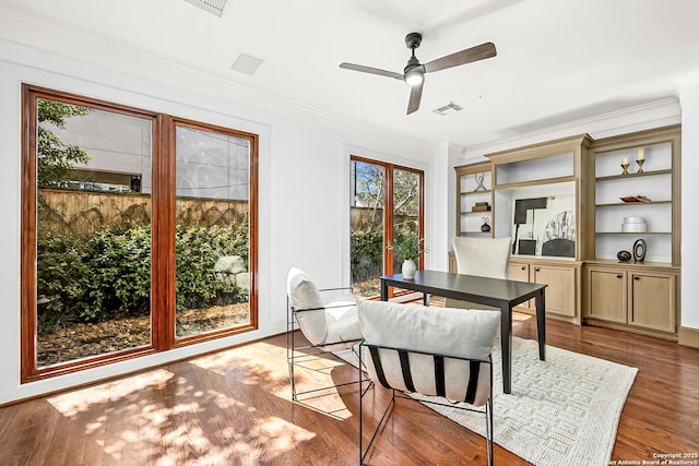 dining room with ornamental molding, visible vents, ceiling fan, and wood finished floors