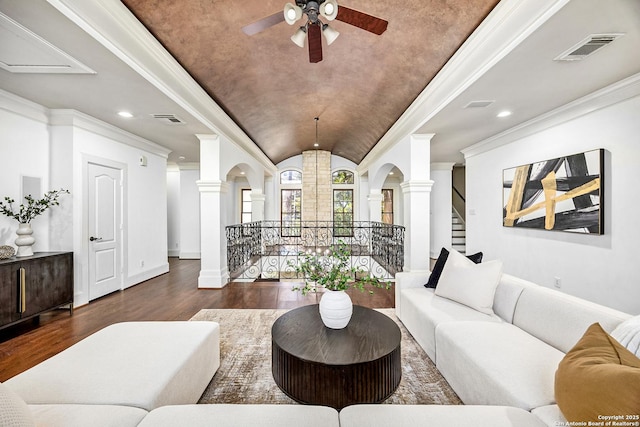 living room featuring wood finished floors, visible vents, stairs, ornamental molding, and ornate columns