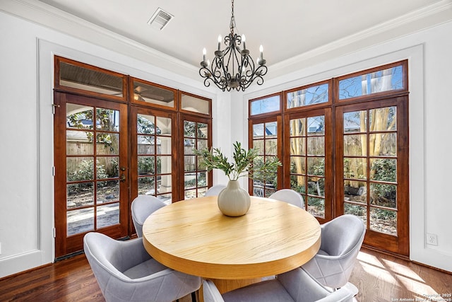 dining area with an inviting chandelier, visible vents, dark wood-style flooring, and ornamental molding