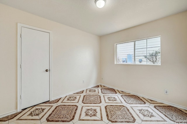 unfurnished room with baseboards