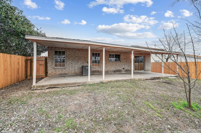 rear view of house featuring brick siding, a patio area, and a fenced backyard