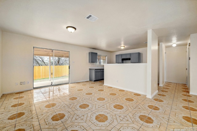 interior space featuring light tile patterned floors, visible vents, and baseboards