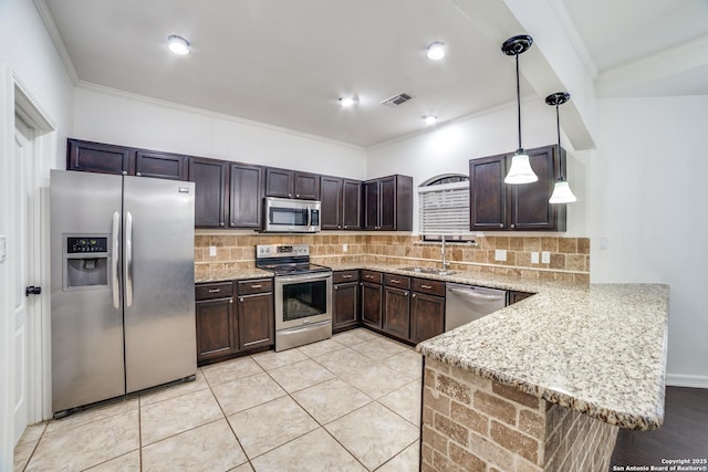 kitchen with tasteful backsplash, appliances with stainless steel finishes, a peninsula, dark brown cabinets, and a sink