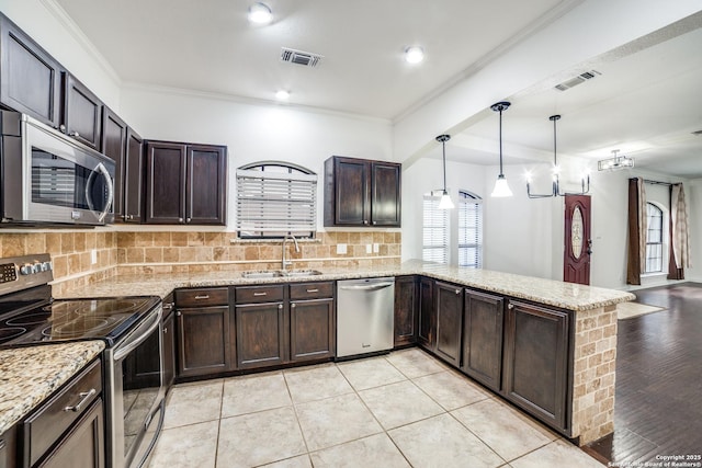 kitchen with backsplash, visible vents, stainless steel appliances, and a sink