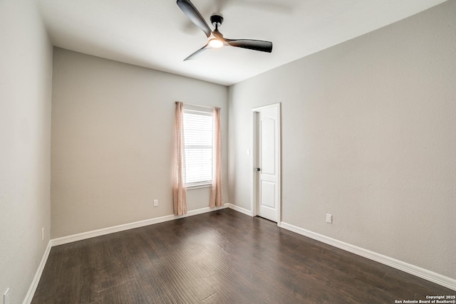 empty room with dark wood-style floors, ceiling fan, and baseboards