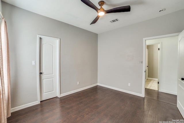 unfurnished bedroom featuring baseboards, visible vents, and dark wood finished floors