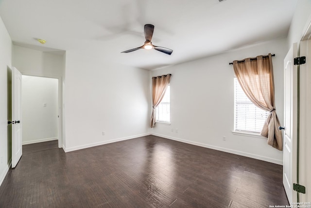 unfurnished room with a ceiling fan, baseboards, and dark wood-type flooring