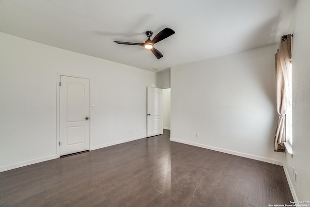 unfurnished room with dark wood-style floors, a ceiling fan, and baseboards