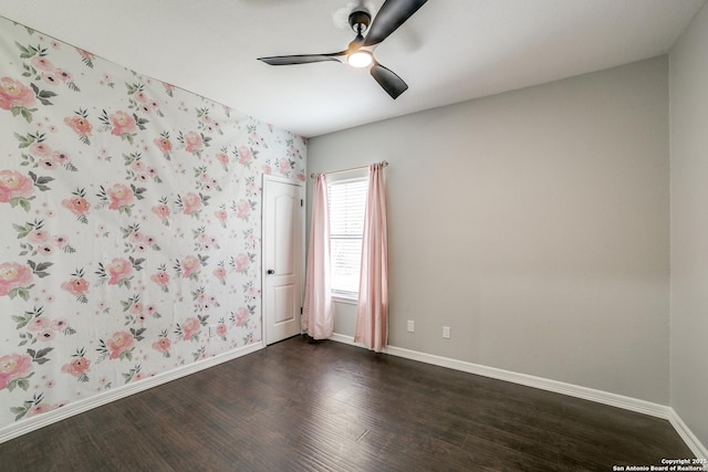 unfurnished room featuring a ceiling fan, dark wood finished floors, baseboards, and wallpapered walls