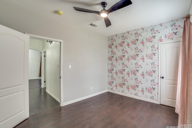 unfurnished bedroom featuring dark wood-style floors, baseboards, visible vents, and wallpapered walls