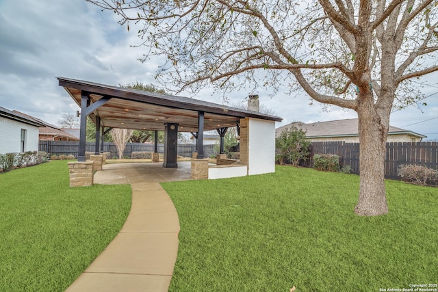 view of community featuring a fenced backyard, a lawn, and a patio