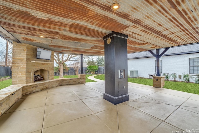 view of patio with a fireplace, fence, and central air condition unit