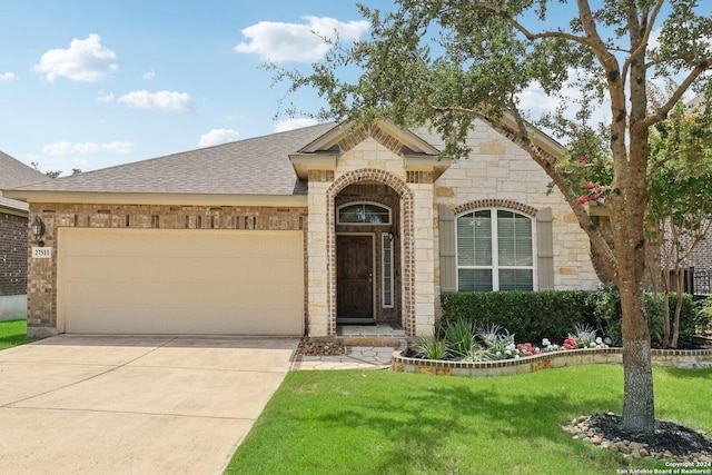 french country style house with driveway, a garage, stone siding, roof with shingles, and a front lawn