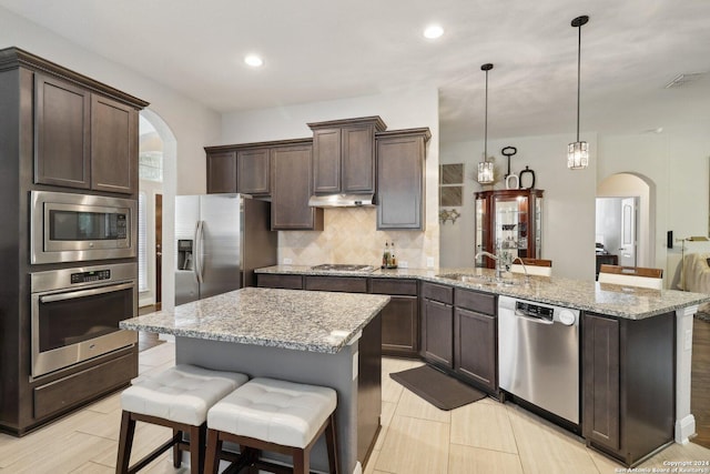 kitchen featuring arched walkways, visible vents, appliances with stainless steel finishes, a sink, and dark brown cabinetry