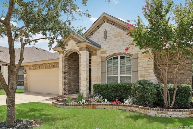 view of front of house with a garage, concrete driveway, stone siding, a front lawn, and brick siding