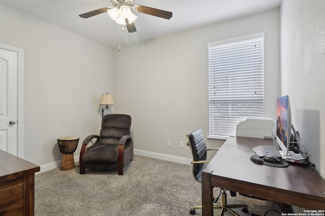 carpeted office space featuring baseboards and a ceiling fan