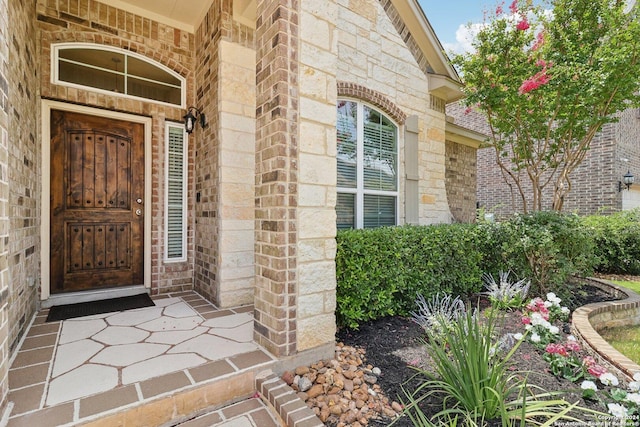 doorway to property with stone siding and brick siding