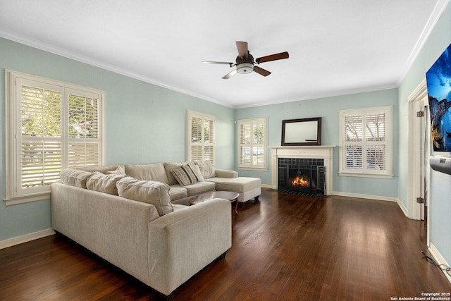 living area with a tile fireplace, baseboards, dark wood-type flooring, and ornamental molding