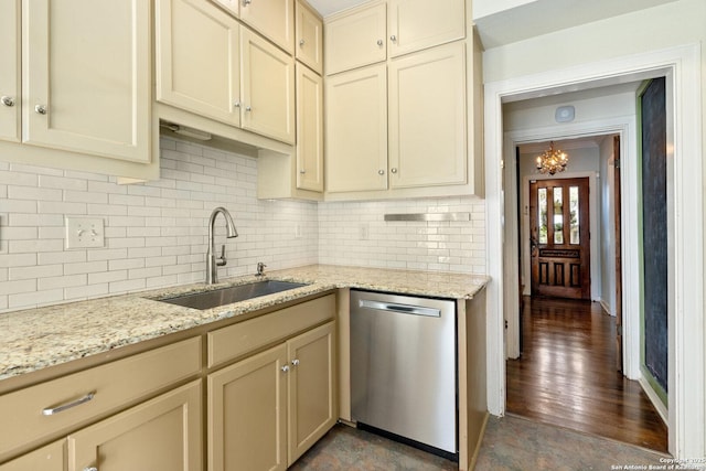 kitchen with a sink, cream cabinets, decorative backsplash, and dishwasher