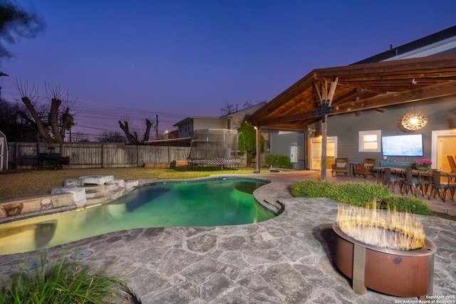 view of pool with a trampoline, a patio area, fence, and a fenced in pool