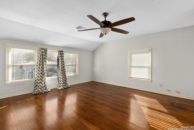 unfurnished room featuring lofted ceiling, visible vents, baseboards, and hardwood / wood-style flooring