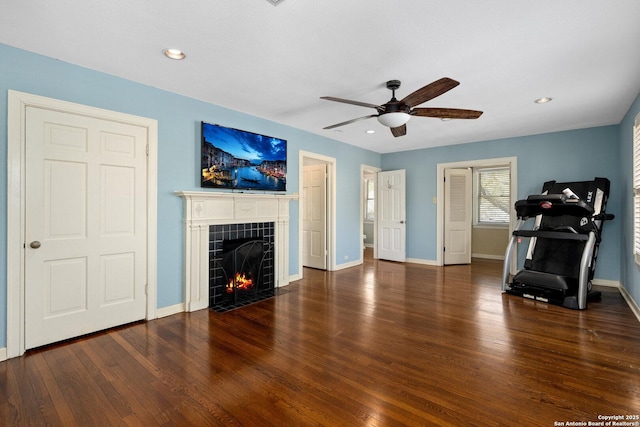 living room with recessed lighting, a tiled fireplace, a ceiling fan, wood finished floors, and baseboards