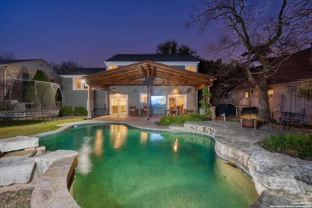 pool featuring a grill, a trampoline, fence, a gazebo, and a patio area