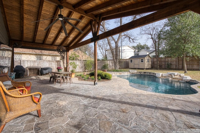 view of pool with a patio area, a shed, a fenced backyard, and an outdoor structure