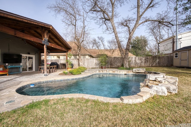 view of swimming pool featuring an outbuilding, a shed, a patio area, and a fenced backyard
