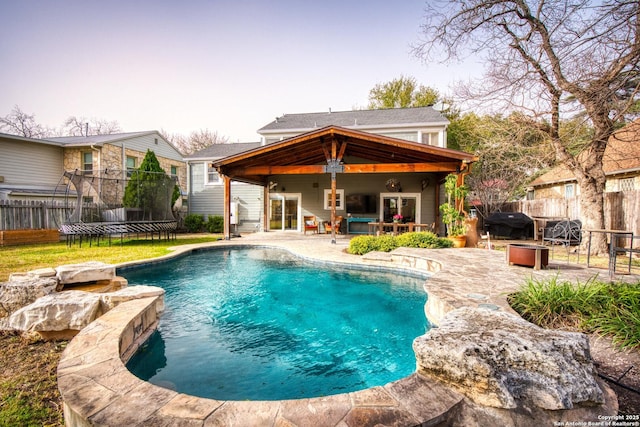 view of swimming pool with a fenced in pool, a fenced backyard, a grill, a trampoline, and a patio area
