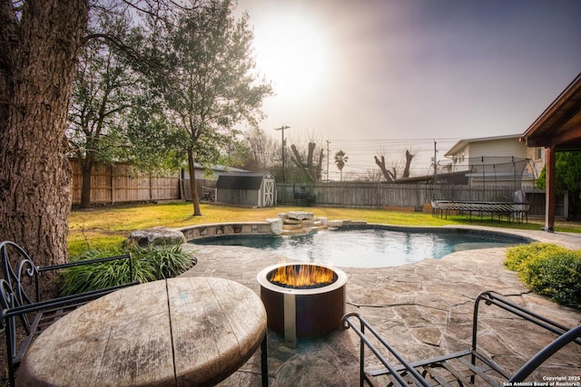 view of swimming pool with an outdoor structure, a fenced backyard, a patio, and a storage shed