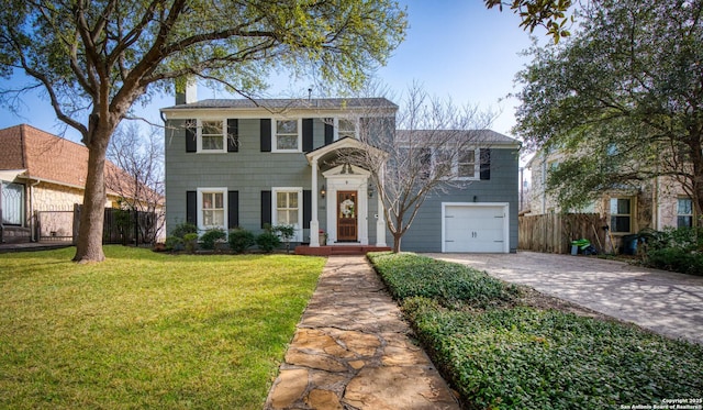 traditional-style house with driveway, a garage, a chimney, fence, and a front yard