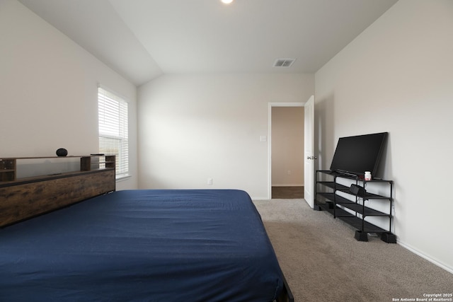 bedroom featuring lofted ceiling, baseboards, visible vents, and carpet flooring