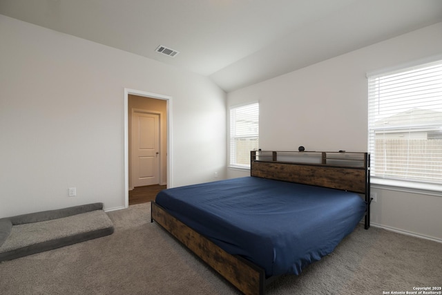 carpeted bedroom featuring lofted ceiling, visible vents, and baseboards