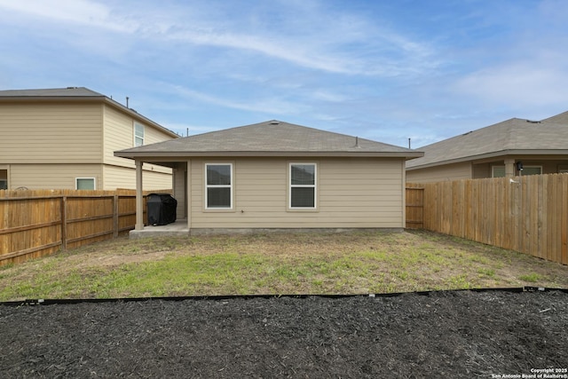 back of house featuring a yard, a fenced backyard, and a patio