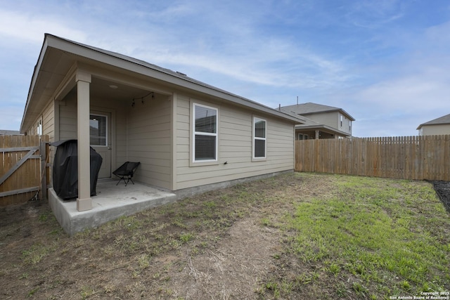 rear view of property with a patio, a lawn, and a fenced backyard