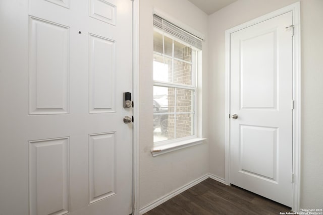 doorway featuring dark wood-style flooring and baseboards