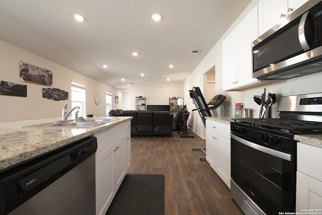 kitchen featuring white cabinets, appliances with stainless steel finishes, dark wood-style flooring, and a sink