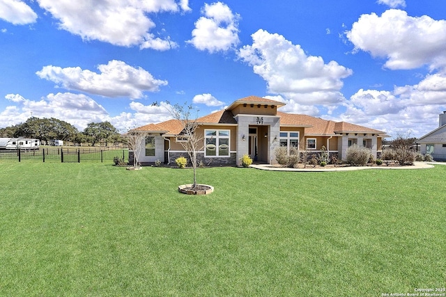 view of front of home featuring stone siding, a front yard, and fence